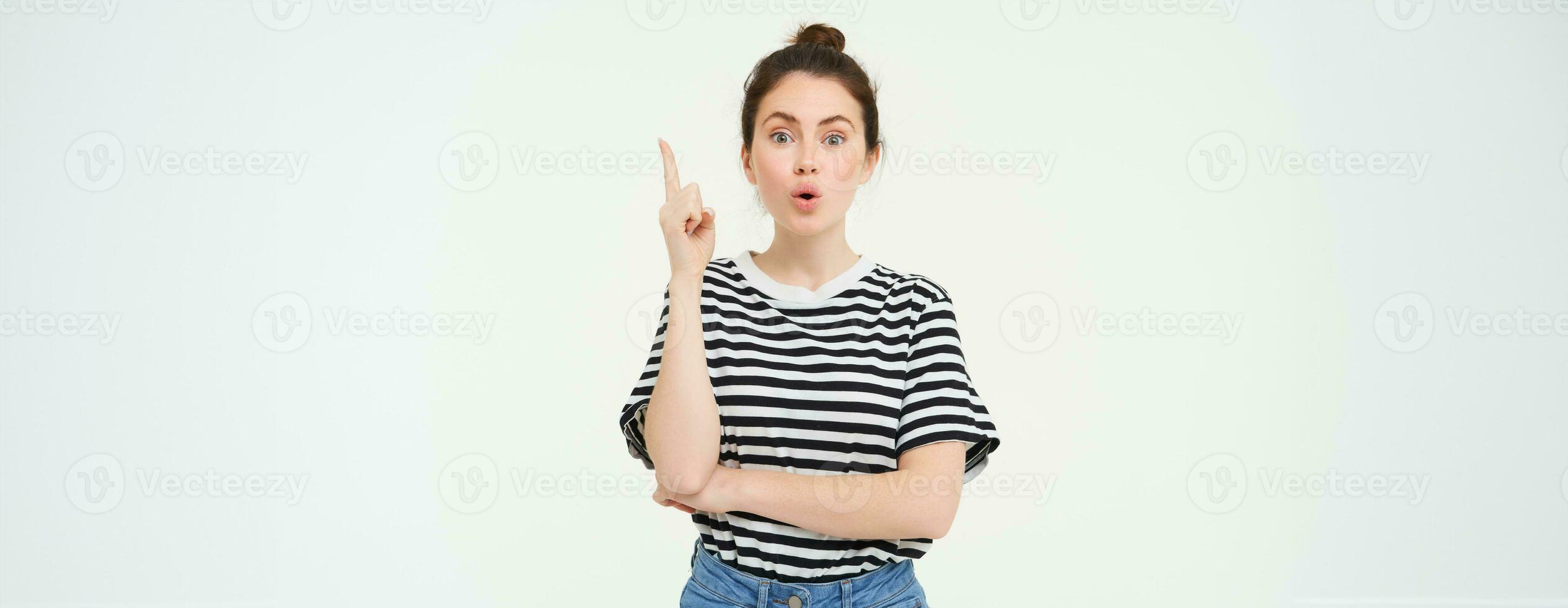 flicka har ett aning. ung kvinna med en lösning, höjning henne finger, föreslår något, står över vit bakgrund foto