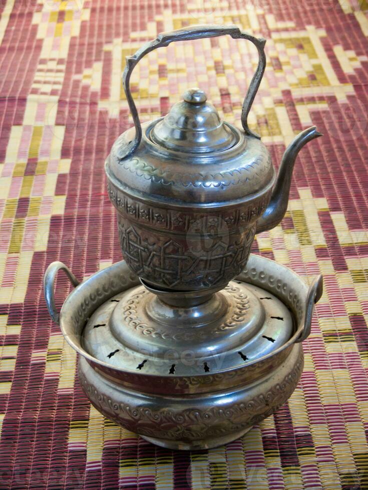 en silver- te pott på topp av en silver- bricka foto