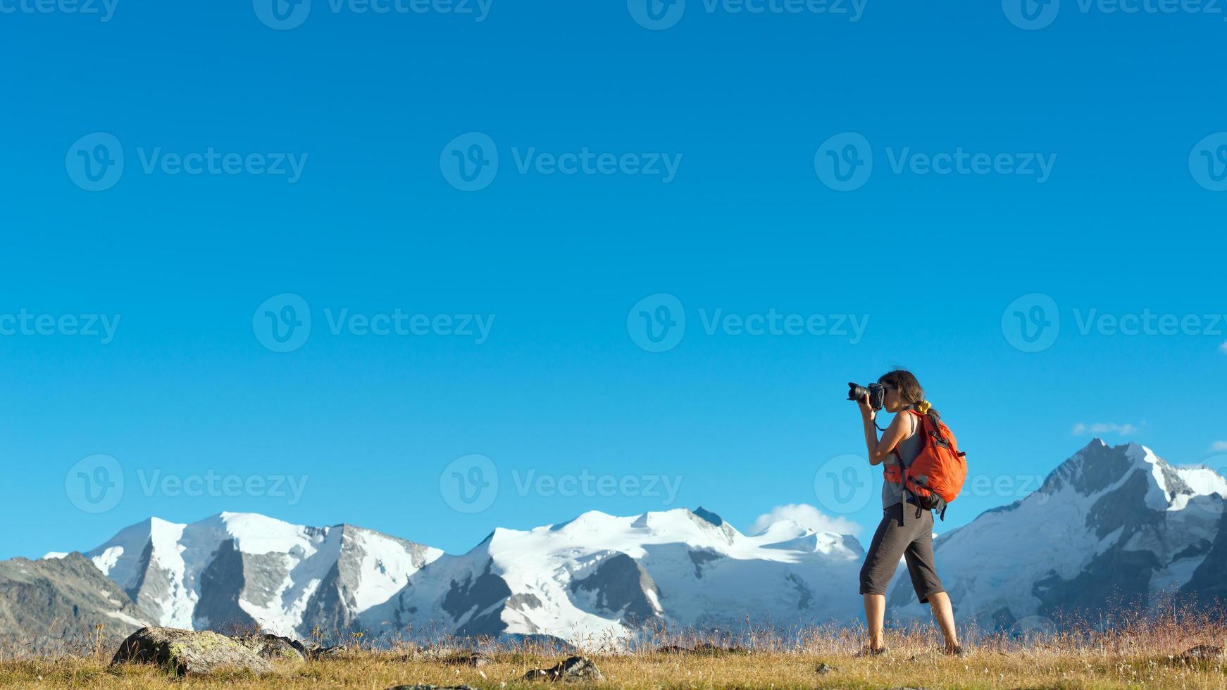 flicka fotograferar höga berg i Alperna foto
