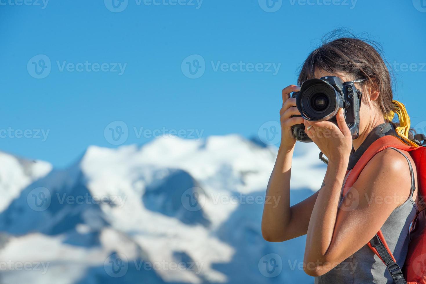 flicka som fotograferar i höga berg foto