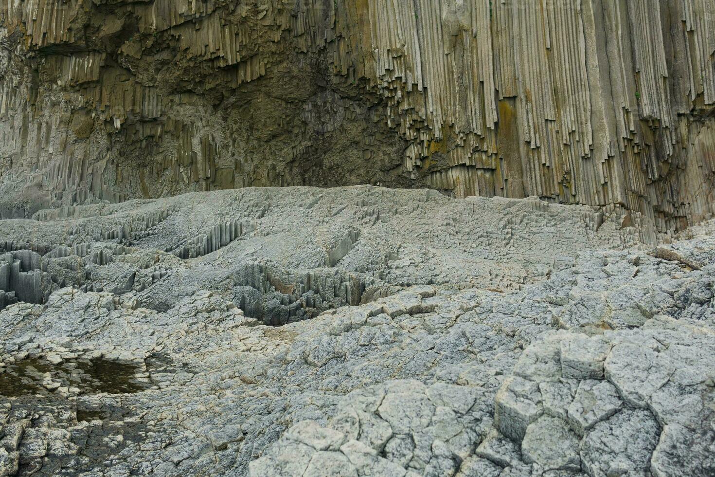 pelar- basalt sten, cape stolbchaty på kunashir ö, i de förgrund baser av lava basalt kolonner form en snäll av trottoar foto