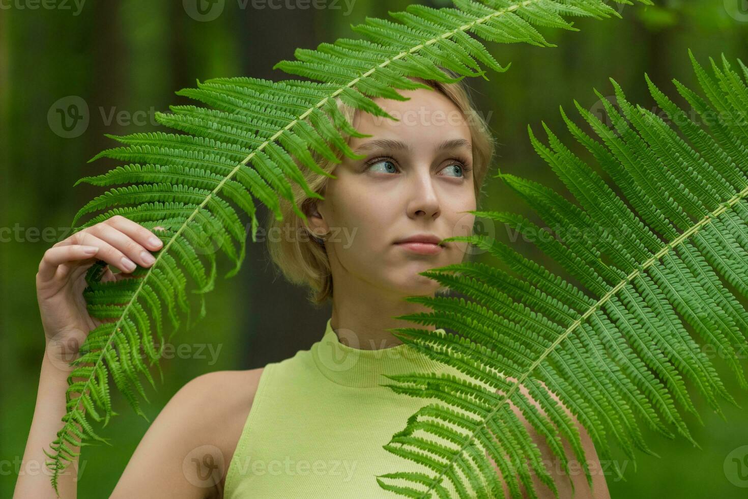 ung skön kvinna bland de ormbunke löv i de skog foto