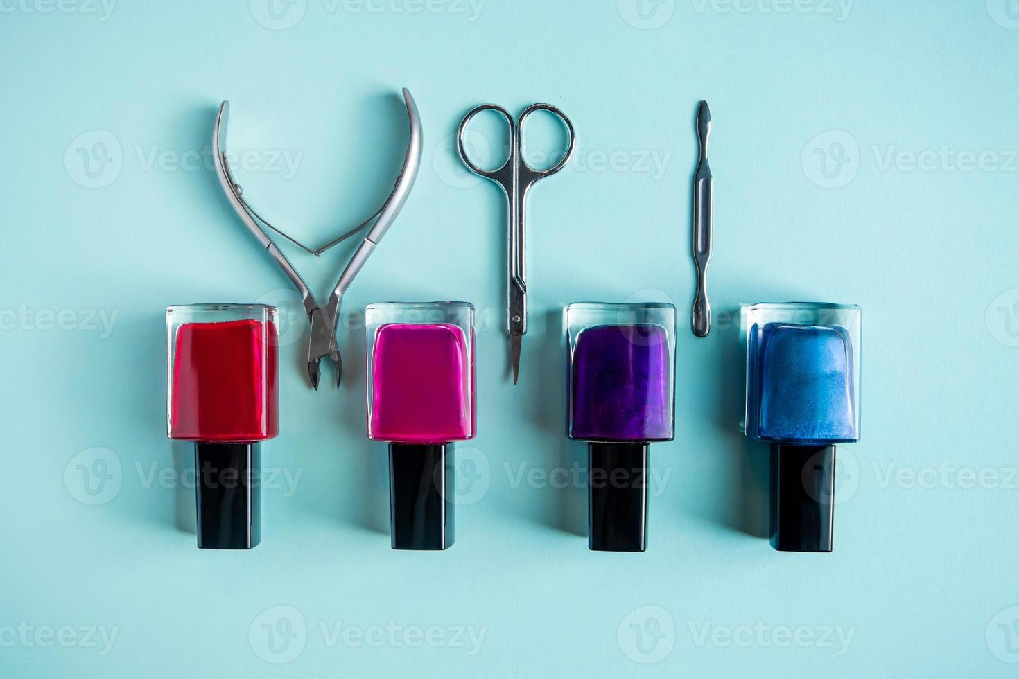 uppsättning verktyg för manikyr och nagelvård på blå bakgrund. spa hand procedur, plats för text. foto