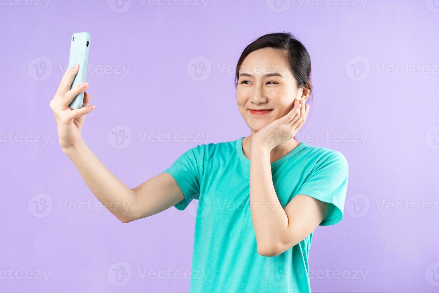 vacker asiatisk kvinna porträtt, isolerad på lila bakgrund foto