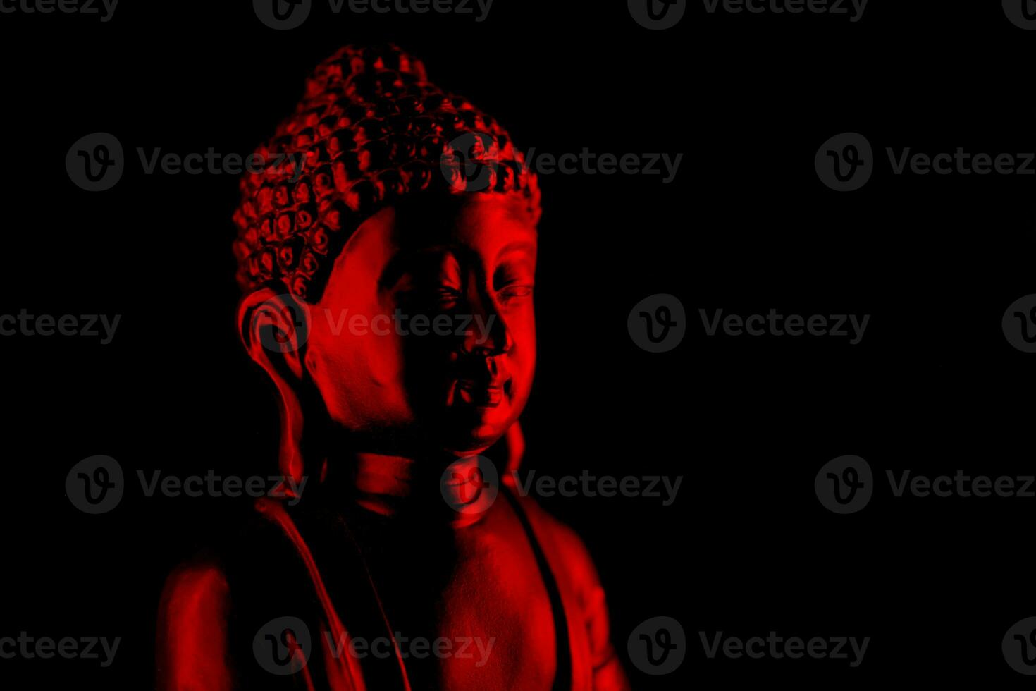 buddha purnima och Vesak dag begrepp, röd buddha staty med låg nyckel ljus mot djup svart bakgrund foto