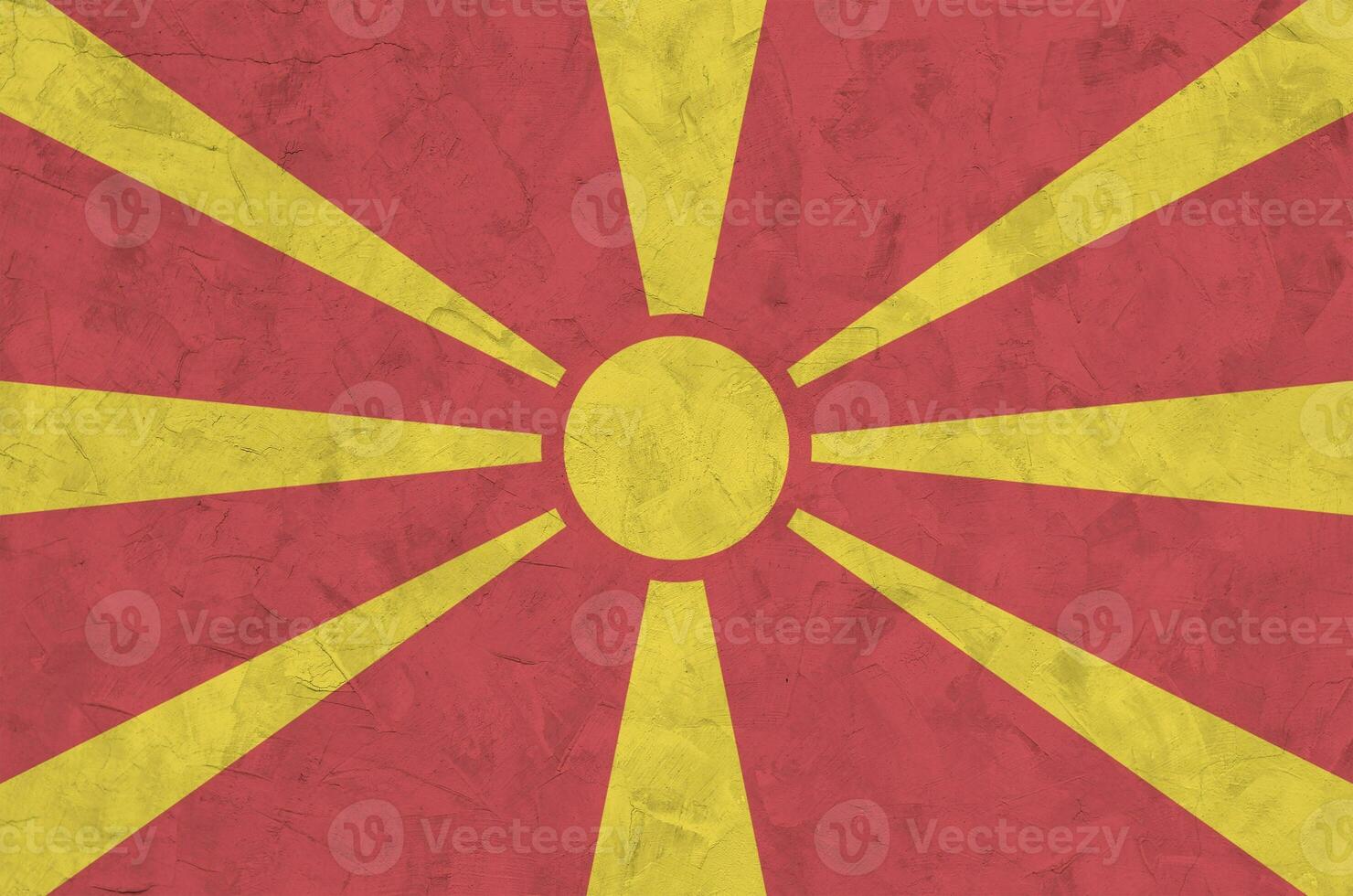 macedonia flagga avbildad i ljus måla färger på gammal lättnad putsning vägg. texturerad baner på grov bakgrund foto