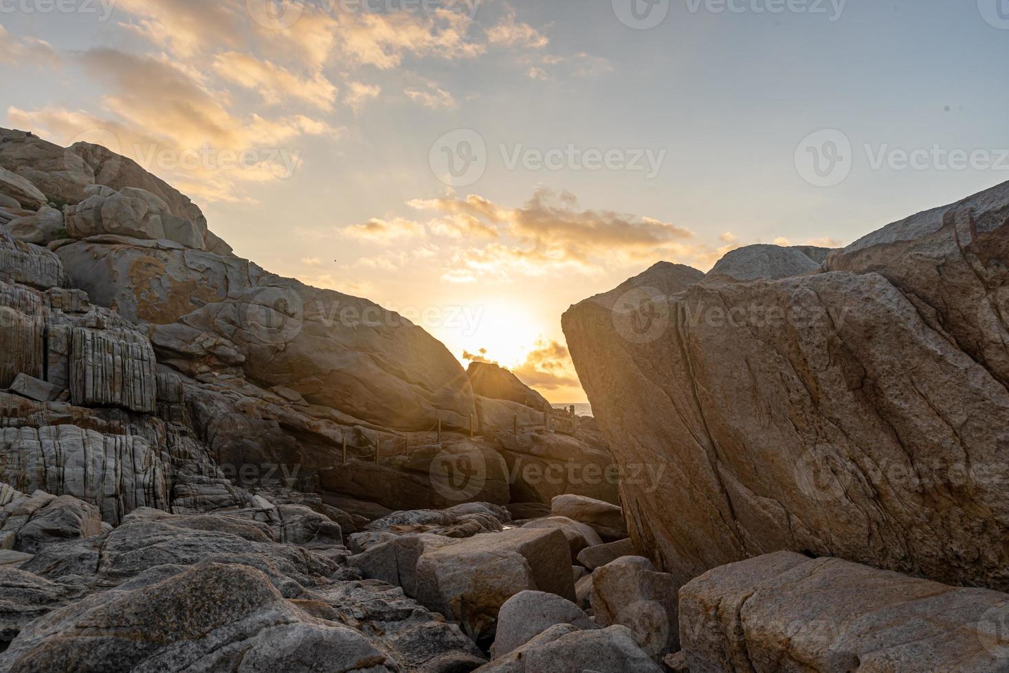 stenar av olika former vittrade av havet under den blå himlen foto