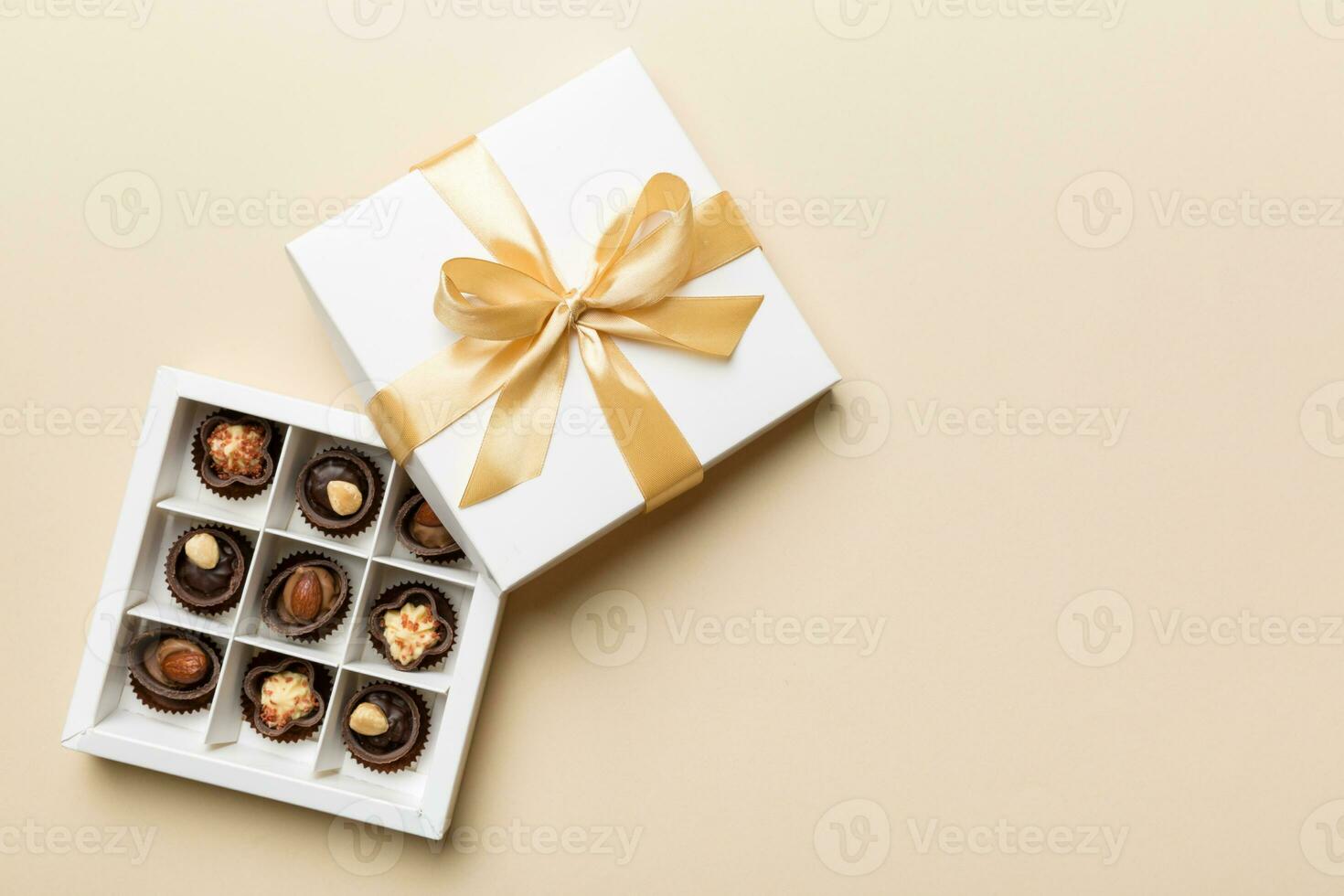 vit låda med choklad godis och gyllene tejp. topp se med kopia Plats foto