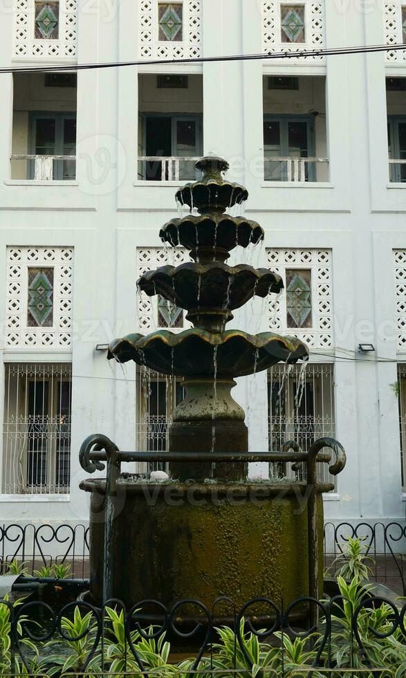 klassisk mång trött sten fontän. antik dekoration i trädgård. foto
