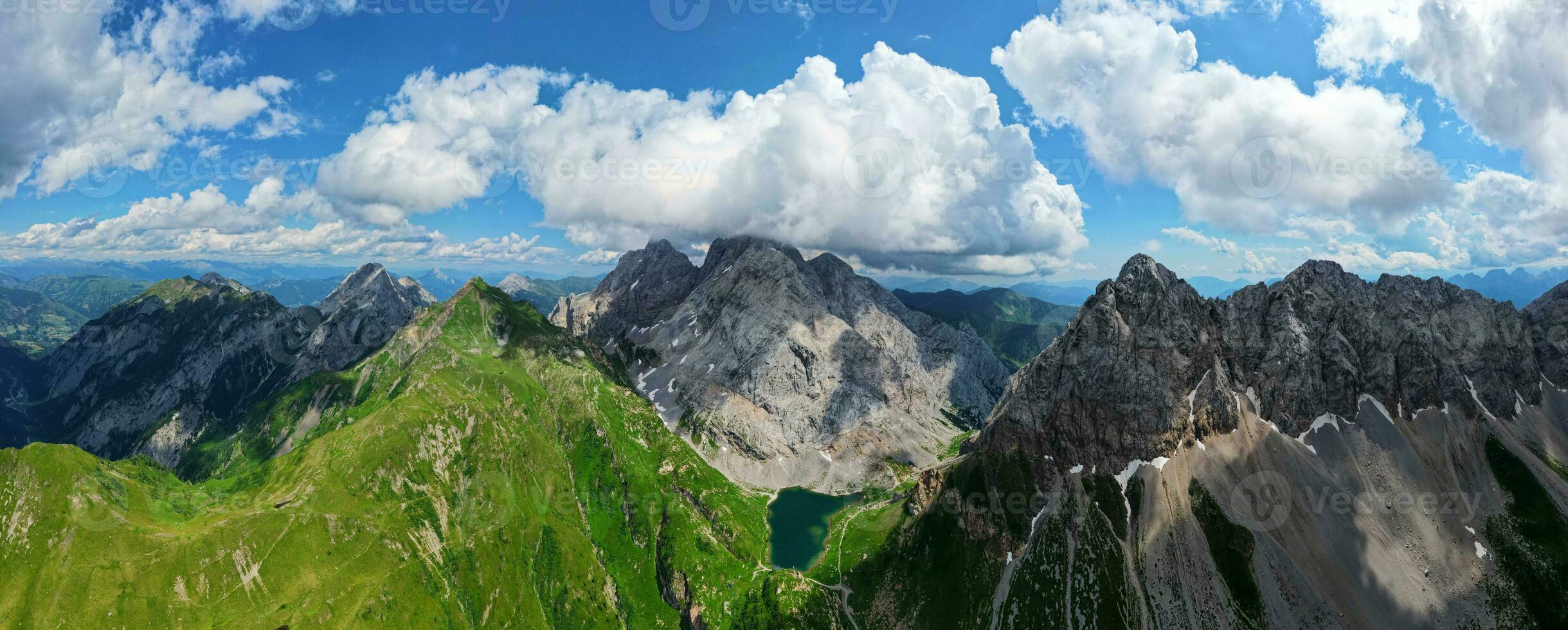 antenn panorama- se av volaia sjö, wolayersee, i de gräns av Italien och österrike med coglians berg i de bakgrund. molnig dag med några Sol öppning. vibrerande färger. foto