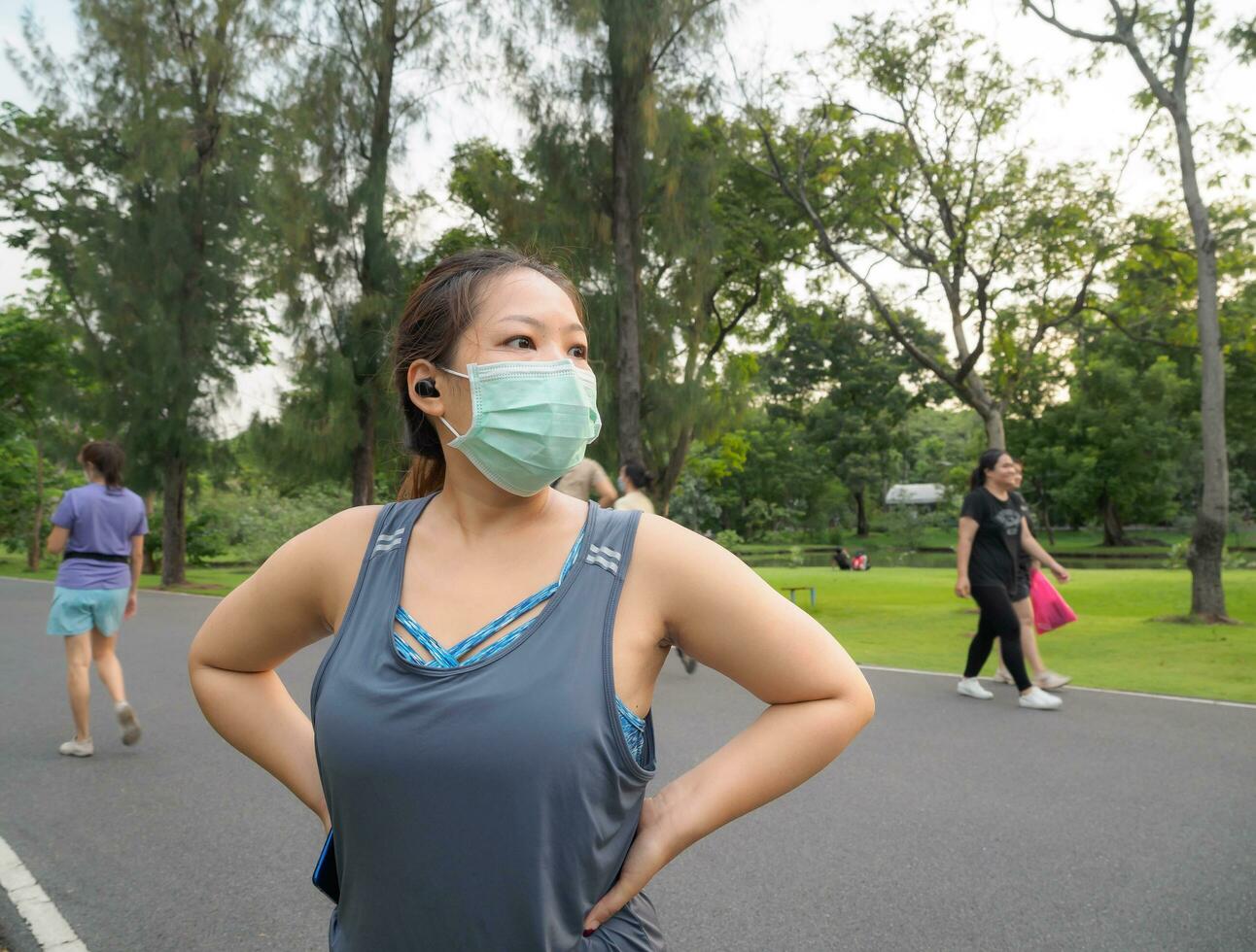 porträtt av en skön asiatisk kvinna i sportkläder, stående med henne tillbaka, stretching innan utövar utomhus- i de parkera i de morgon- till uppnå en friska livsstil. friska uppvärmningen upp foto