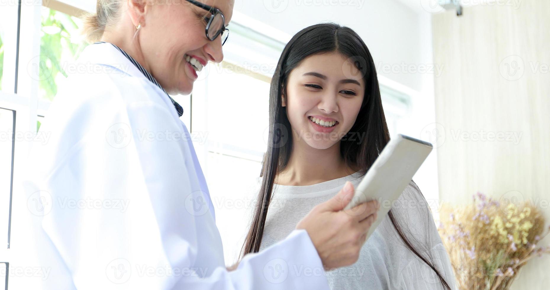 läkarmöte och förklarar medicinering för kvinnlig patient på hans kontor på sjukhus foto