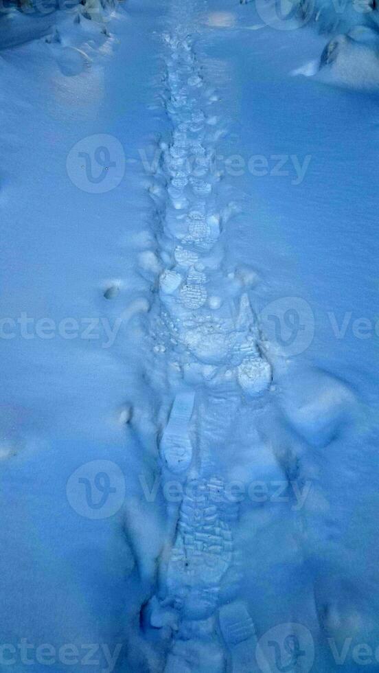 fotspår i de snö. snöig yta med mänsklig spår. vinter- landskap foto