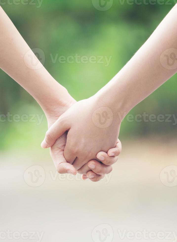 två asiatiska kvinnor håller händerna foto