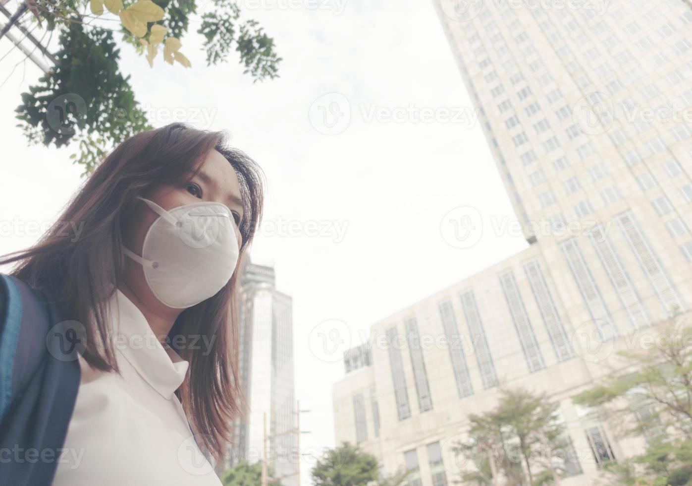 kvinna som bär skyddsmask på stadsgatan foto
