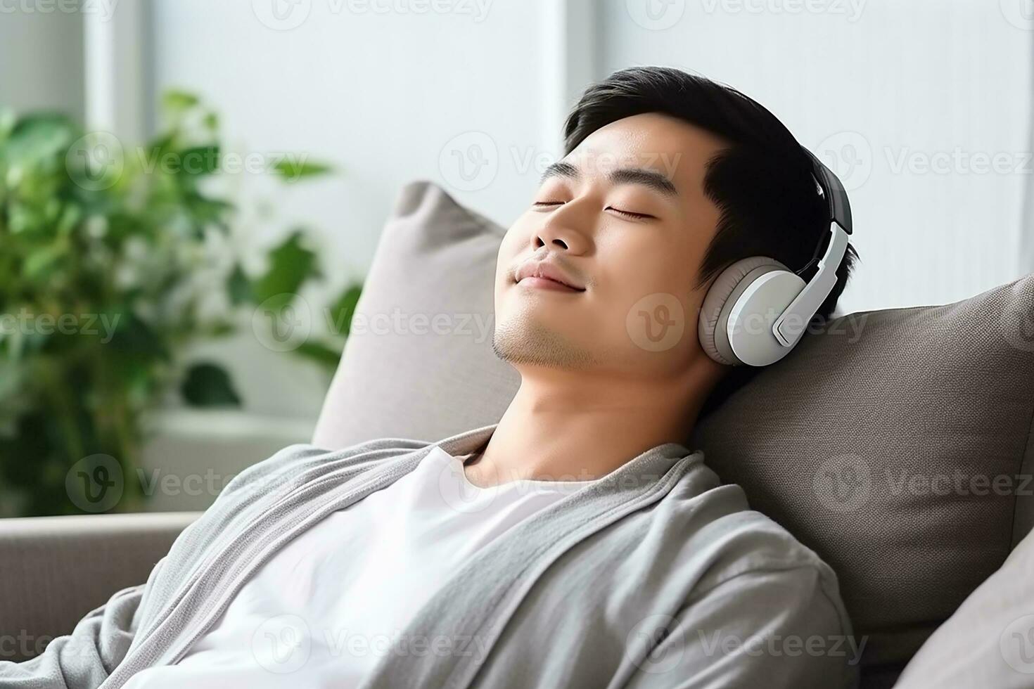 ai genererad lugna asiatisk man Sammanträde på soffa lyssnande till musik ljudbok njuter meditation för sömn och fred foto