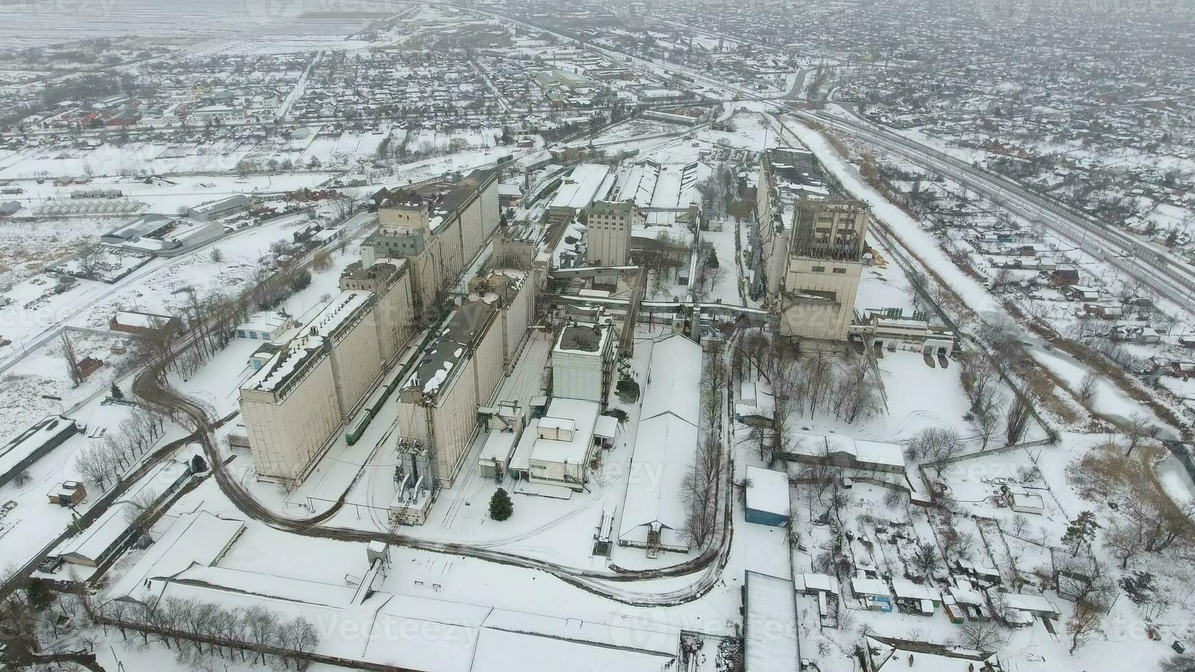 spannmål terminal i de vinter- säsong. snötäckt spannmål hiss i lantlig områden. en byggnad för torkning och lagring spannmål. foto