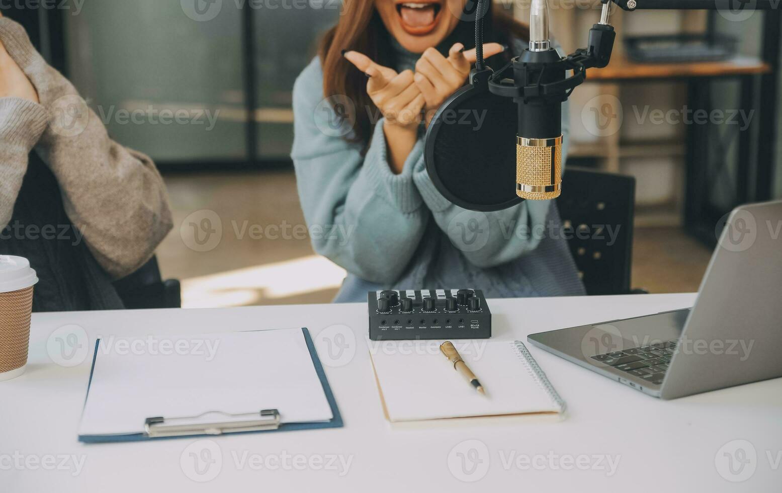 kvinna inspelning en podcast på henne bärbar dator dator med hörlurar och en mikroskop. kvinna podcaster framställning audio podcast från henne Hem studio. foto