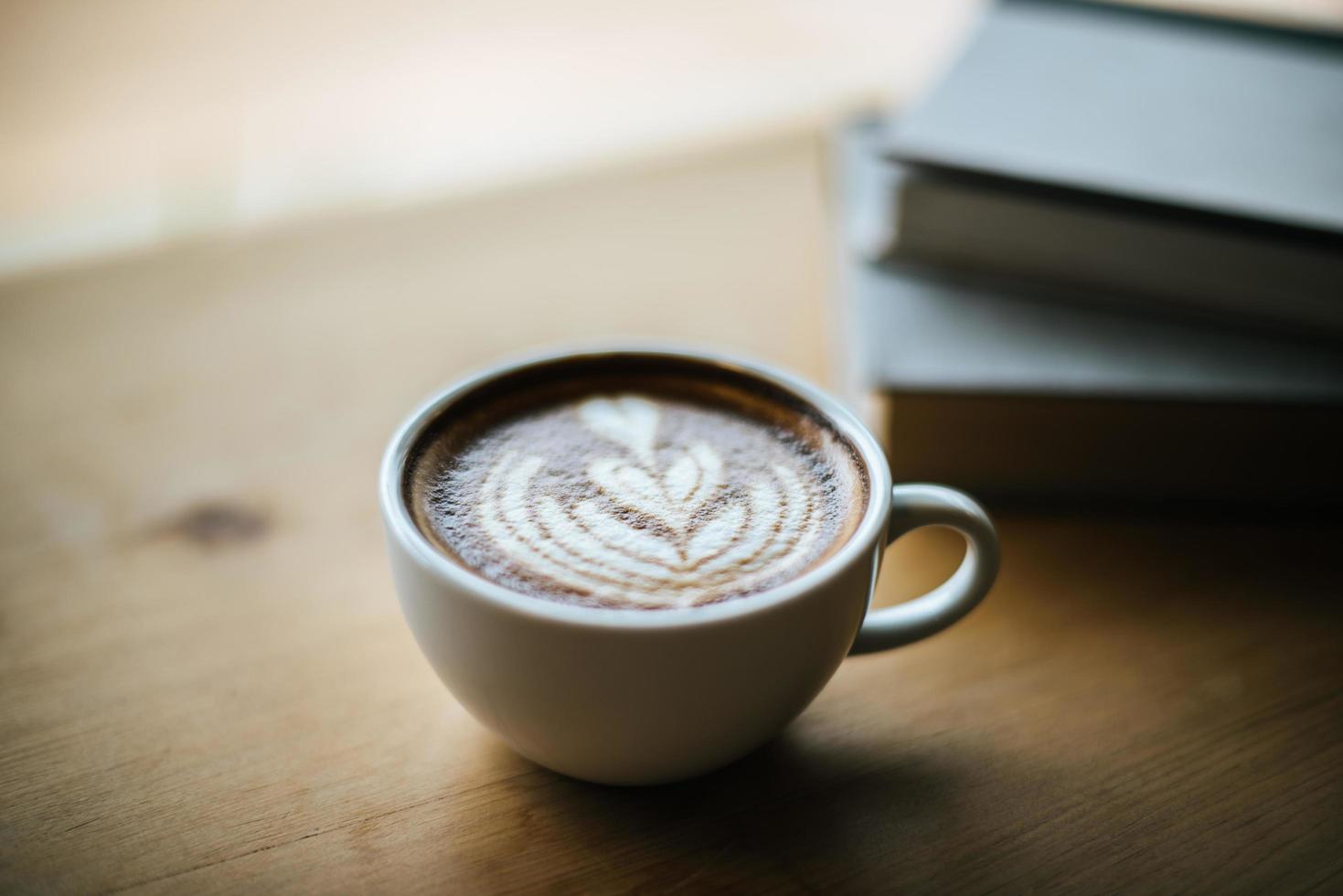 lattekonst i kaffekopp på kafébordet foto