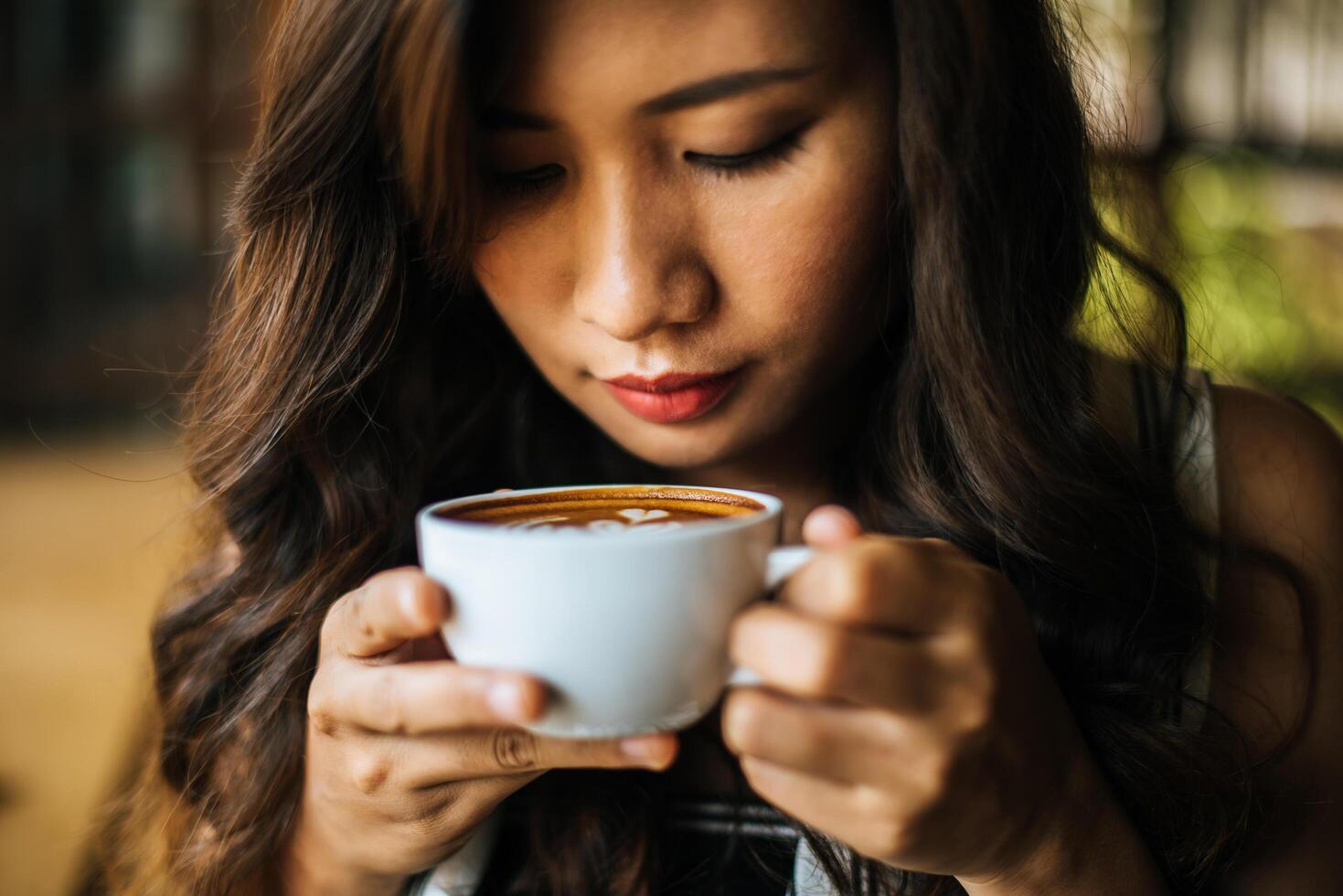 porträtt asiatisk kvinna leende slappna av i caféet foto