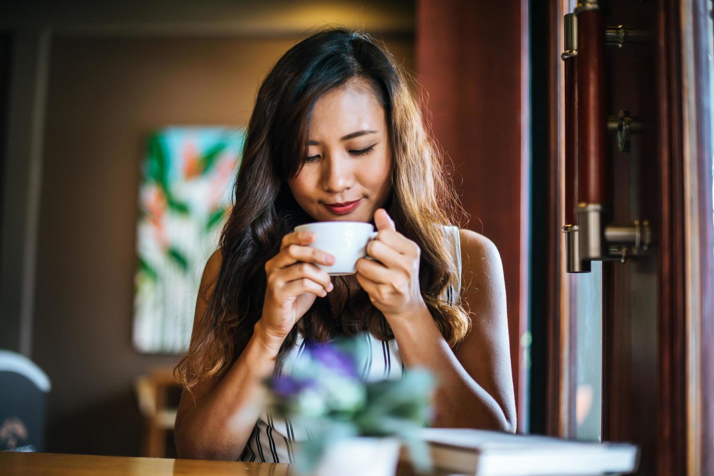 porträtt asiatisk kvinna leende slappna av i caféet foto