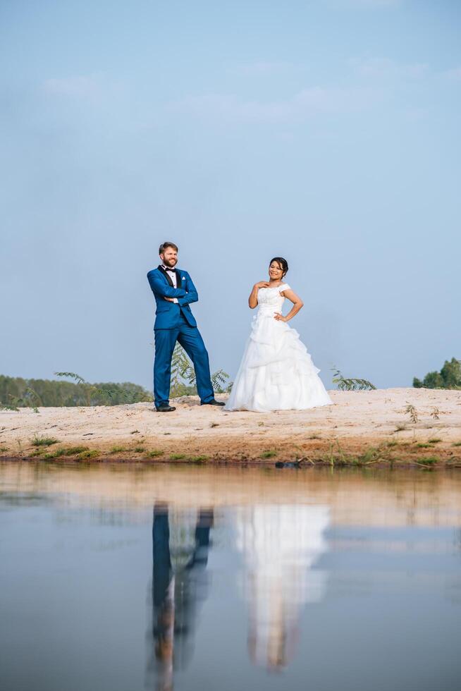 asiatisk brud och kaukasisk brudgum har romantisk tid och är lyckliga tillsammans foto