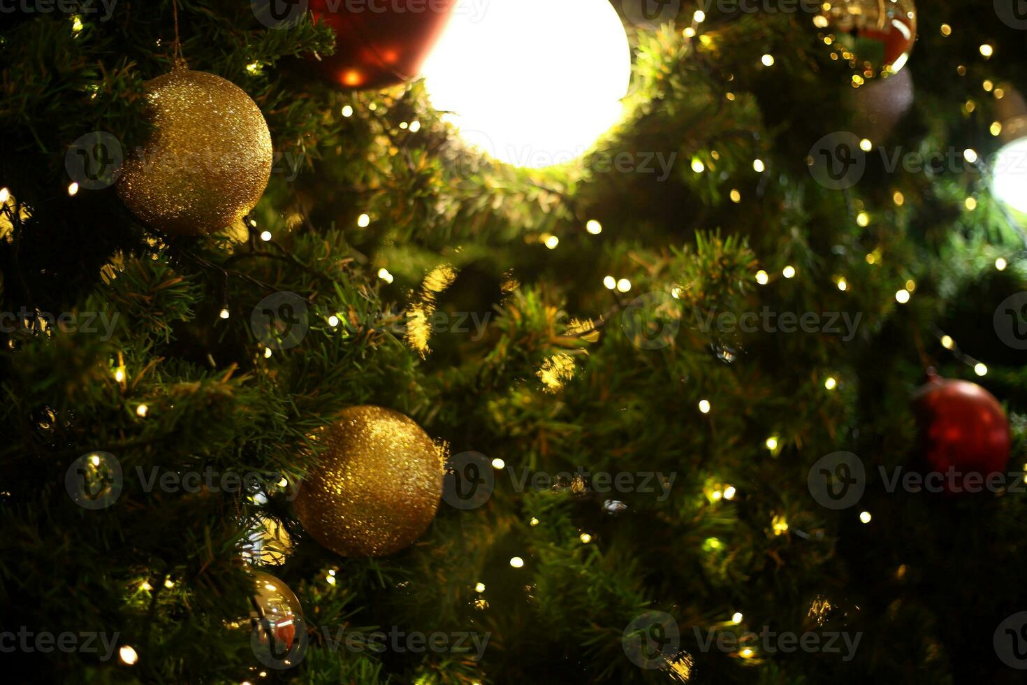 stänga upp dekoration boll och ljus Glödlampa på jul träd på natt foto