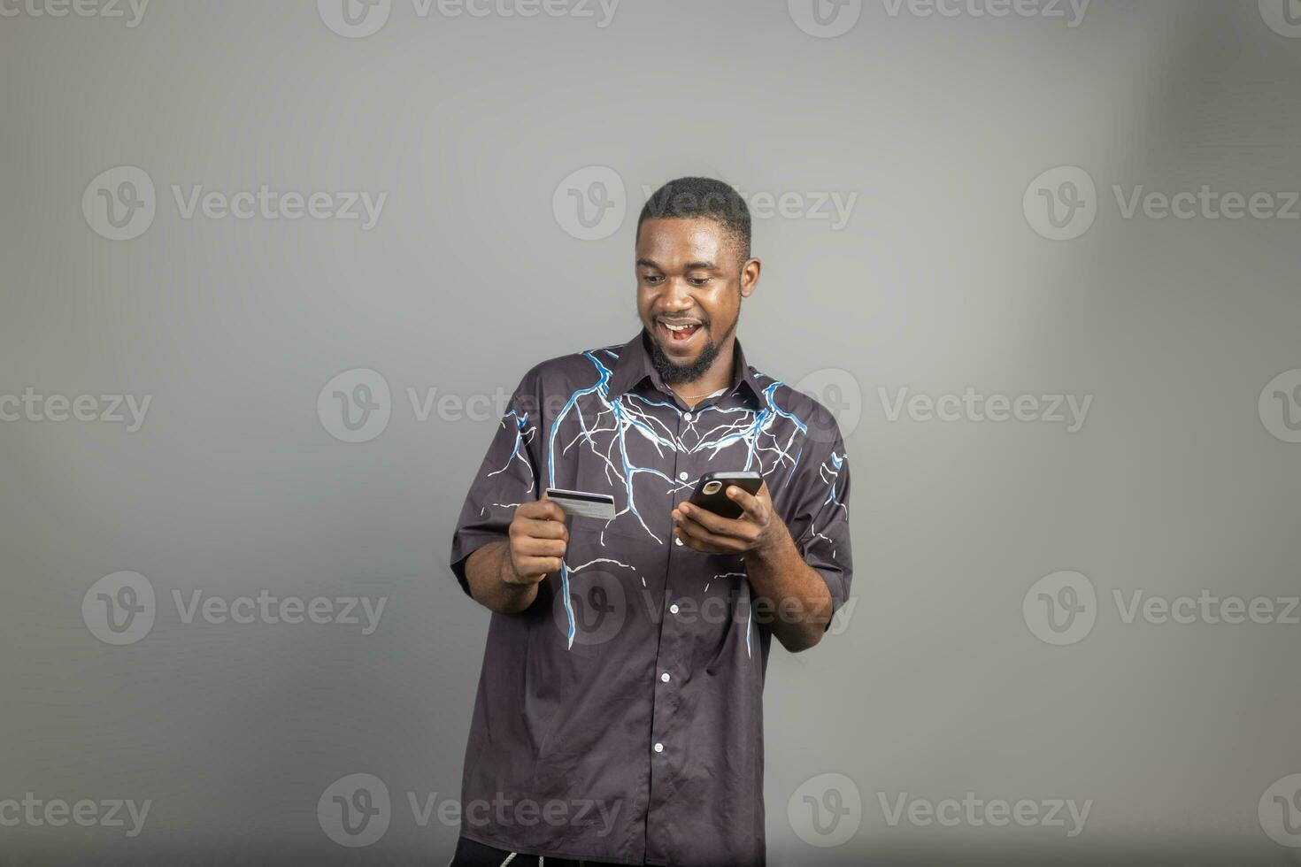 stilig ung svart man använder sig av hans kreditera kort och telefon till affär uppkopplad, bank uppkopplad begrepp foto