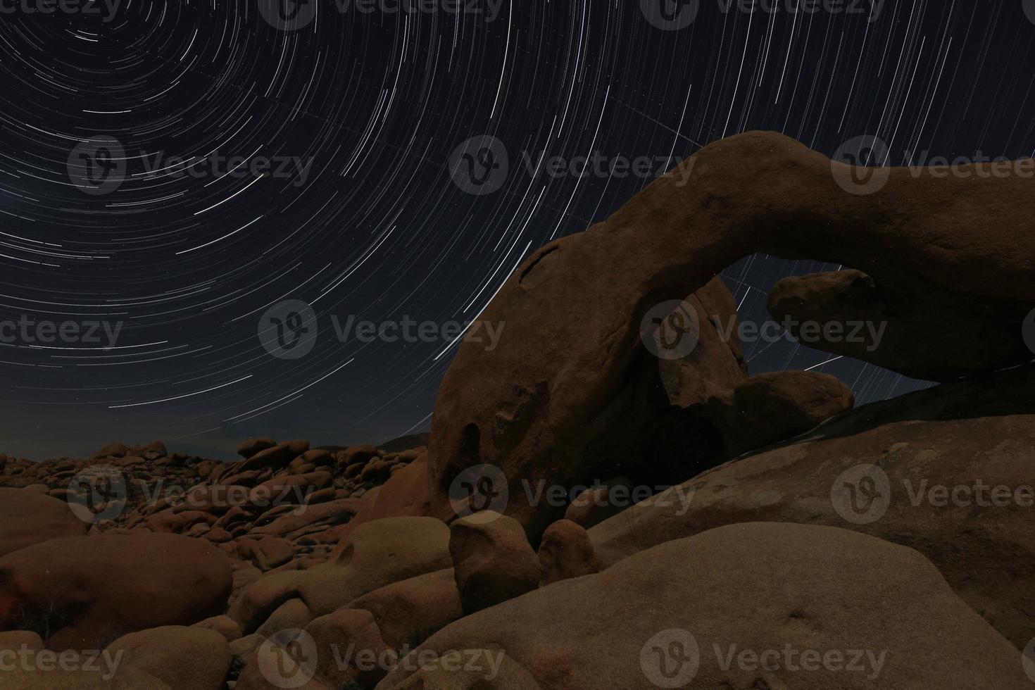 nattstjärnspår ränder över klipporna i Joshua Tree Park foto