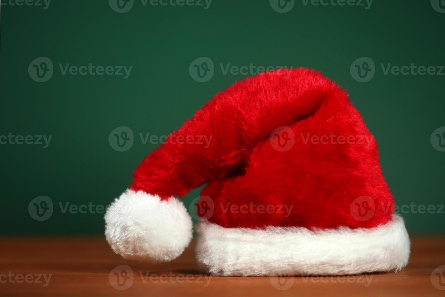 röd santa hatt med kopia utrymme på grön och trä bakgrund foto