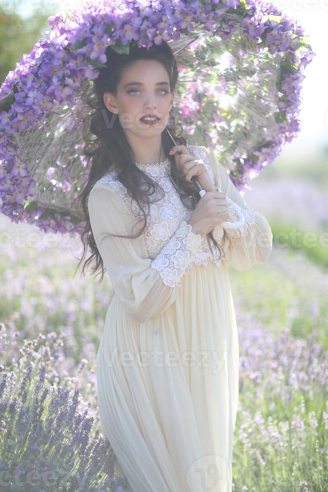 vacker ung flicka utomhus i ett lavendelblommefält foto
