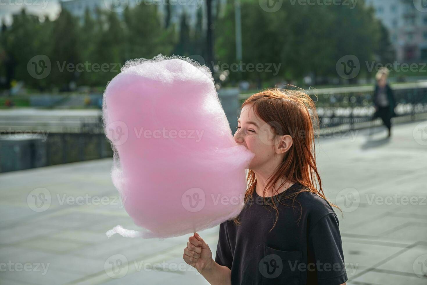 söt flicka äter stor rosa bomull godis foto