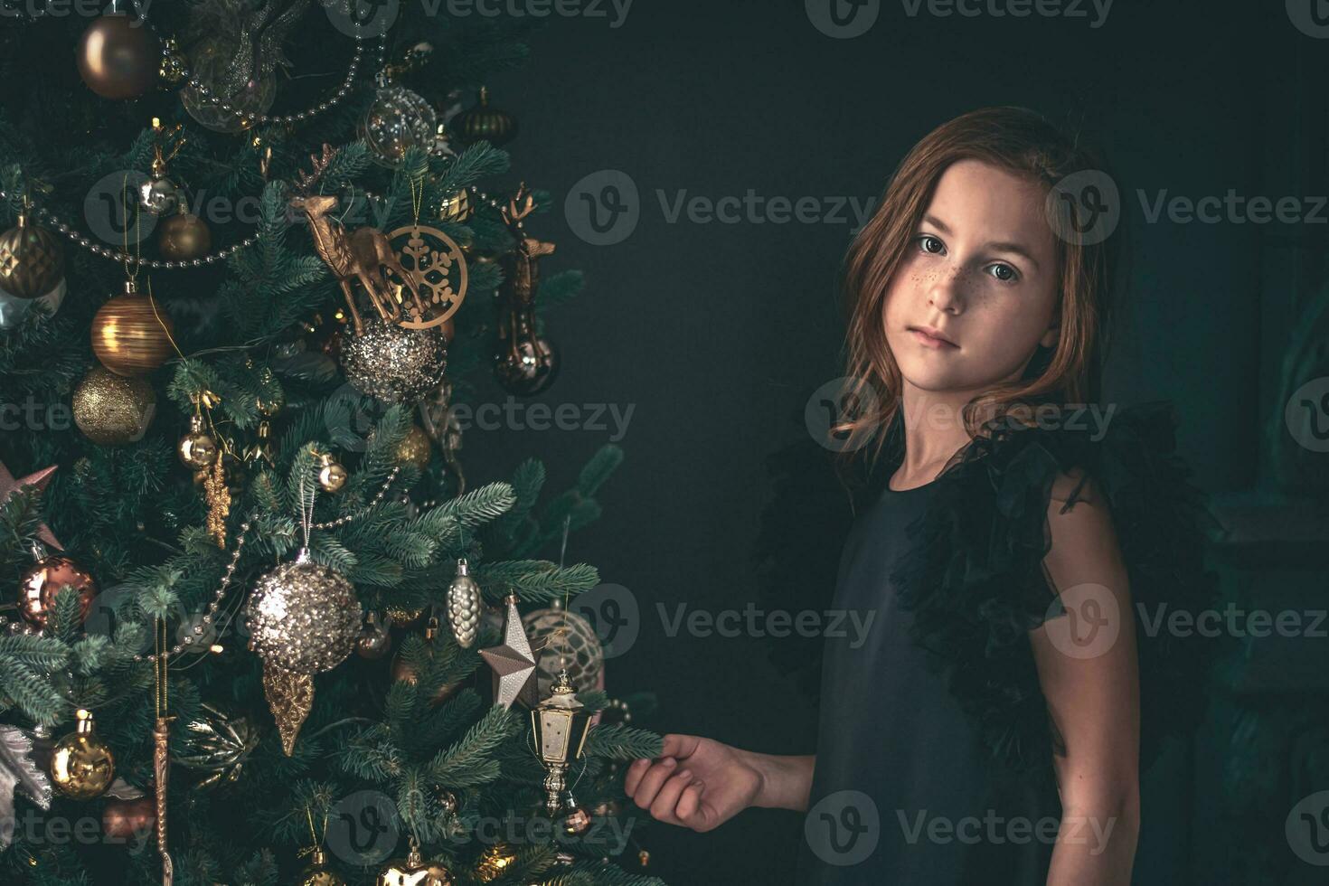 söt liten flicka Nästa till jul träd. jul, ny år, mörk toner foto