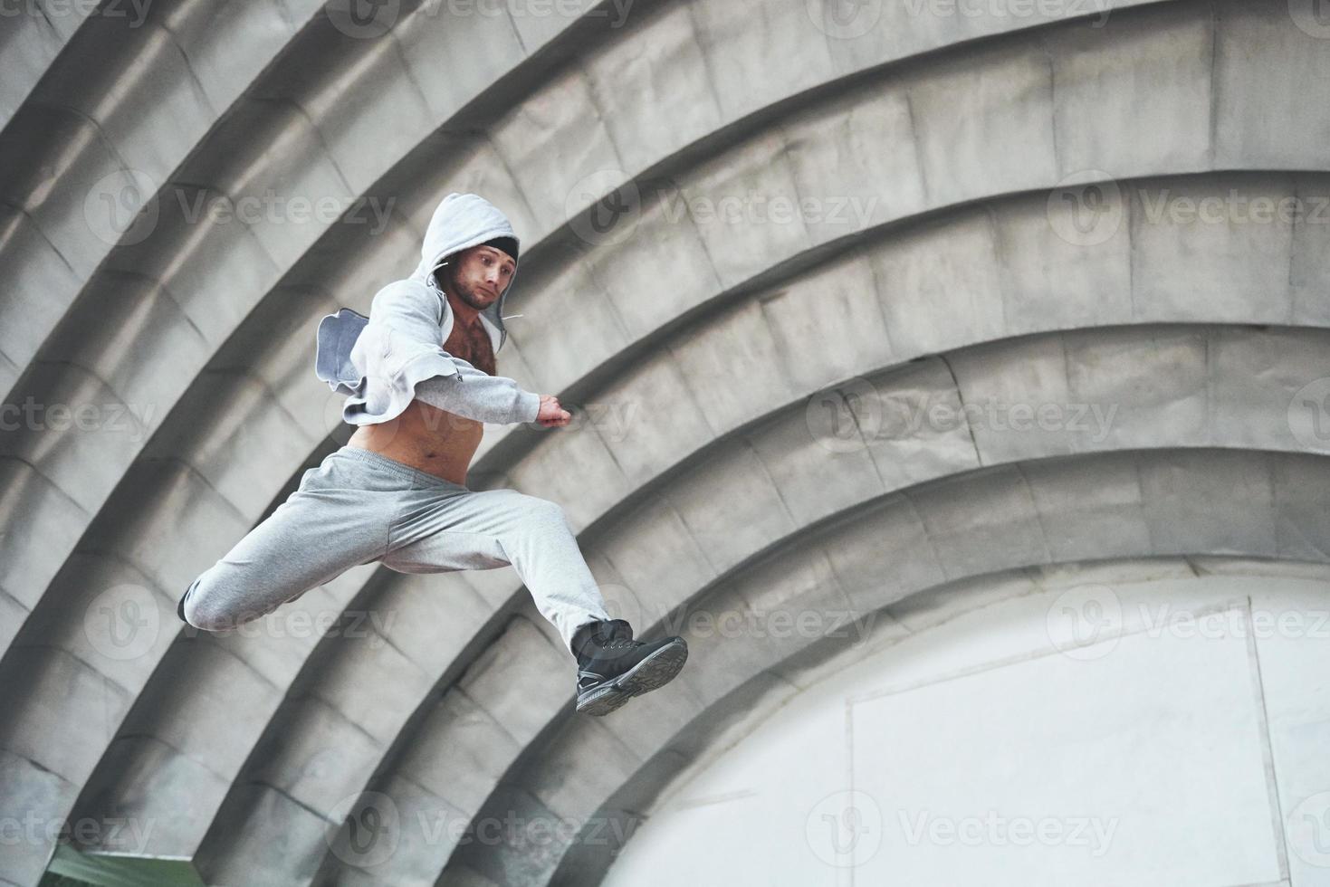 en ung man hoppar. parkour i stadsrummet, sportaktivitet. foto