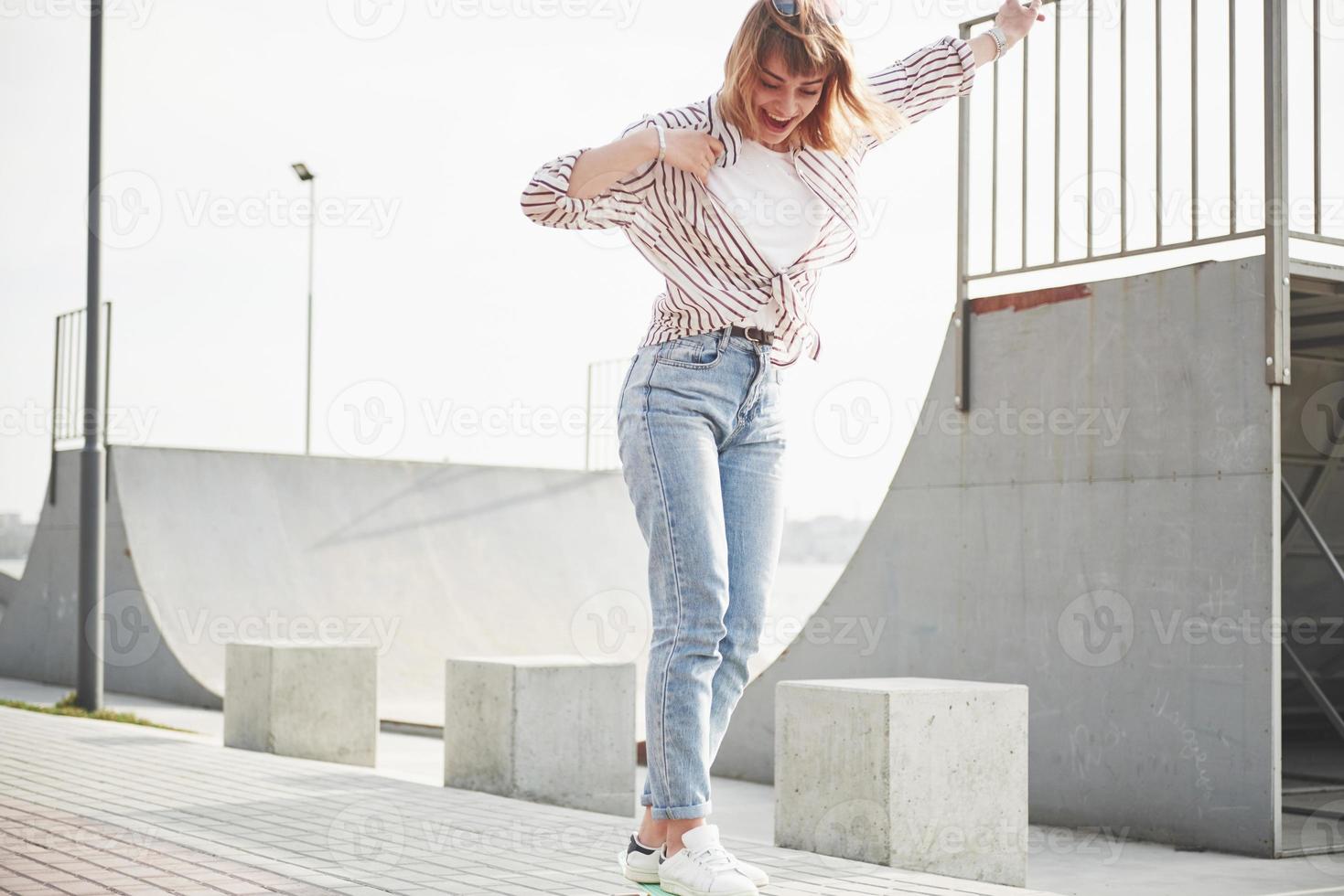 en ung sportkvinna som åker i en park på en skateboard. foto