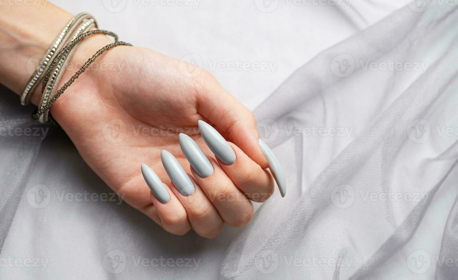 grå naglar på grå spets bakgrund. foto