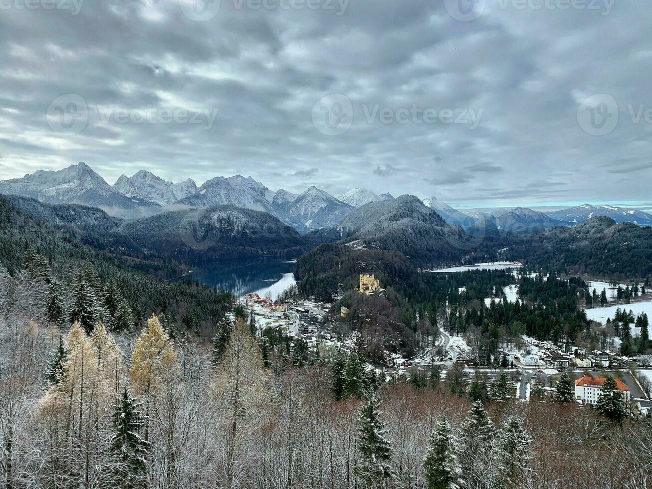 alpina idyll med alpsee, snötäckt skogar och bergen och hohenschwangau slott foto