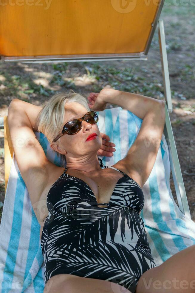 charmig kvinna i baddräkt Framställ i de natur av en parkera i sommar foto