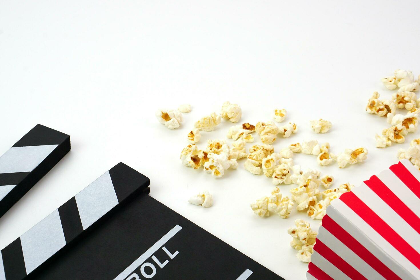 clapperboard eller film skiffer svart Färg med popcorn på vit bakgrund. bio industri, video produktion och filma begrepp. foto