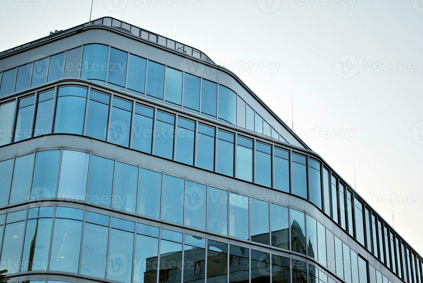 glas byggnad med transparent Fasad av de byggnad och blå himmel. strukturell glas vägg reflekterande blå himmel. foto