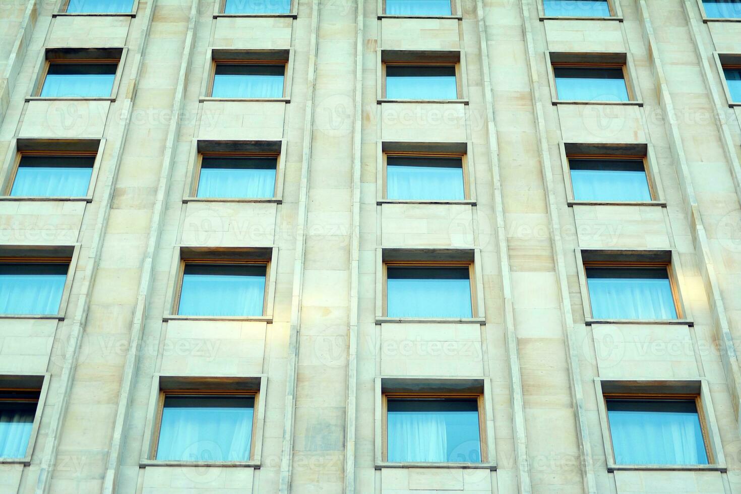 abstrakt närbild av de glasklädd Fasad av en modern byggnad täckt i reflekterande tallrik glas. arkitektur abstrakt bakgrund. glas vägg och Fasad detalj. foto