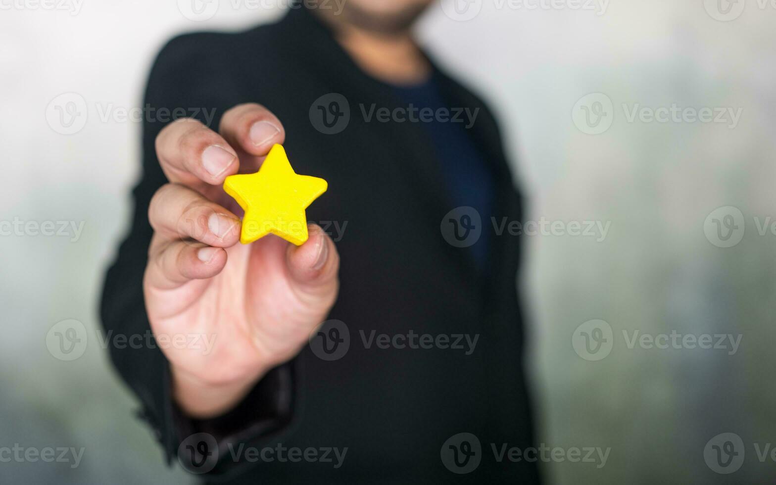 man innehav en gul stjärna. perfekt för känna igen prestationer och Framgång foto