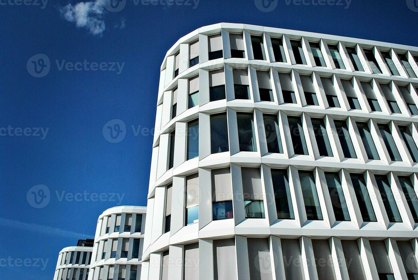 abstrakt närbild av de glasklädd Fasad av en modern byggnad täckt i reflekterande tallrik glas. arkitektur abstrakt bakgrund. glas vägg och Fasad detalj. foto