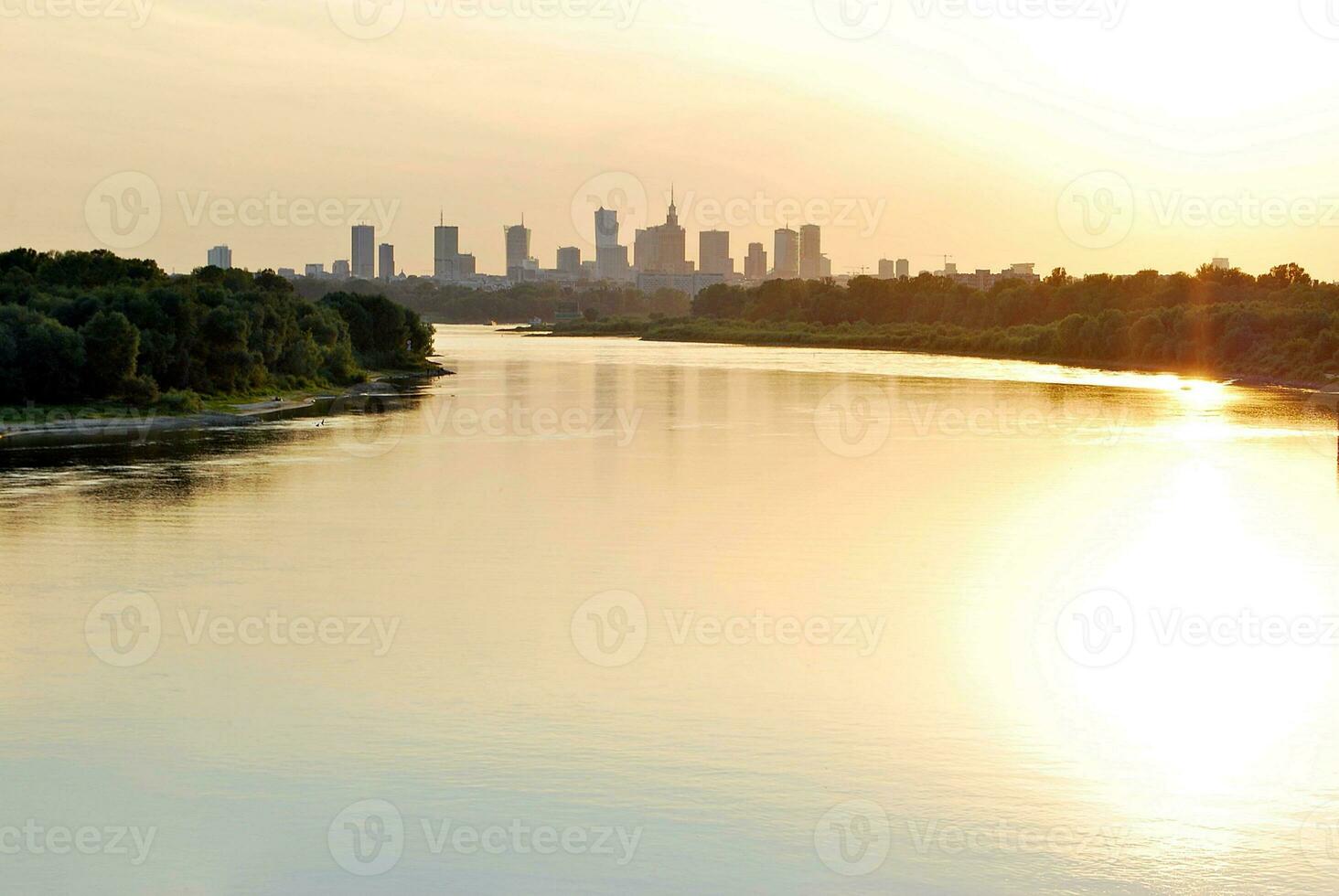flod i de stad i på färgrik solnedgång i de bakgrund foto