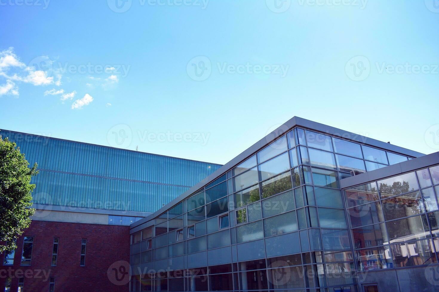 abstrakt närbild av de glasklädd Fasad av en modern byggnad täckt i reflekterande tallrik glas. arkitektur abstrakt bakgrund. glas vägg och Fasad detalj. foto