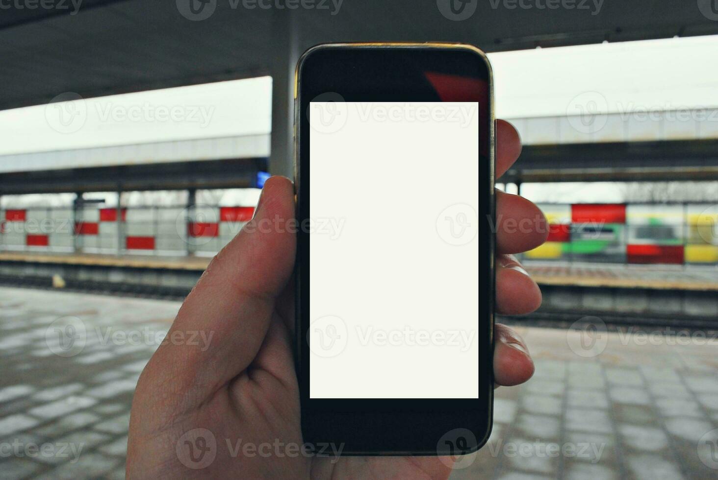 hand innehav smartphone med tunnelbana station bakgrund foto