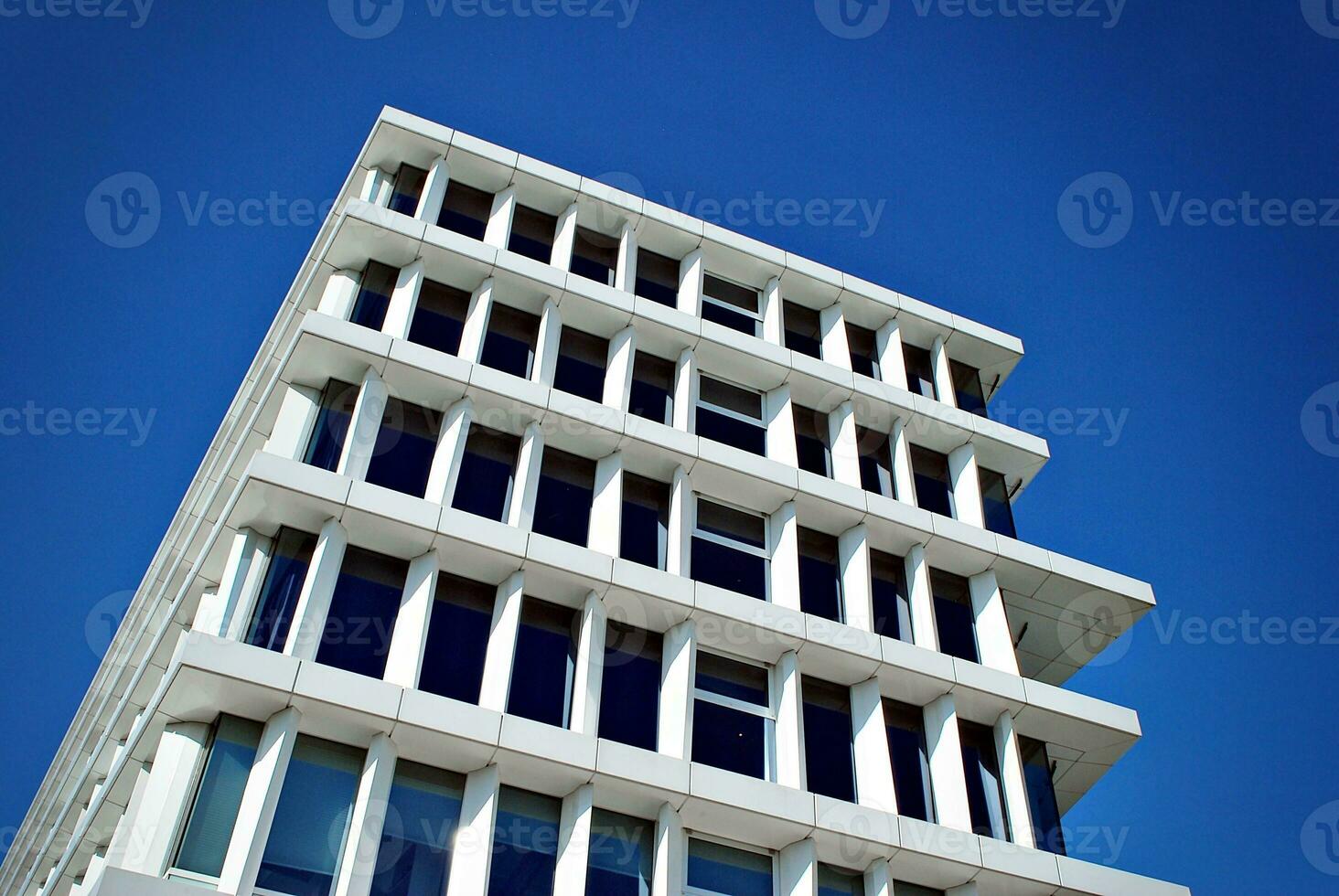 abstrakt närbild av de glasklädd Fasad av en modern byggnad täckt i reflekterande tallrik glas. arkitektur abstrakt bakgrund. glas vägg och Fasad detalj. foto