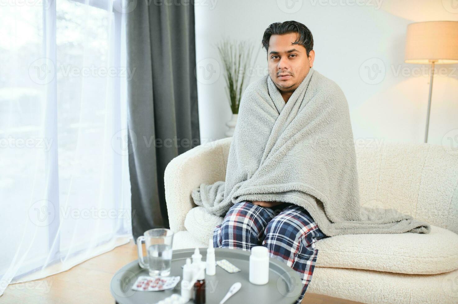 sjuk ung hindu man känsla dålig i de morgon, Sammanträde på säng foto