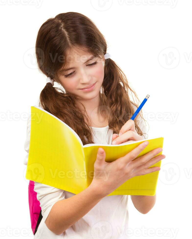 skola flicka skrivning i anteckningsbok foto