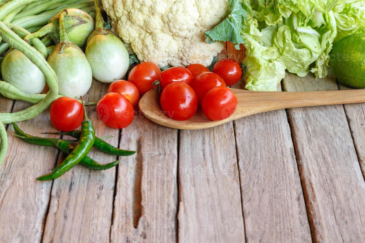 råa blandade grönsaker på träbord foto